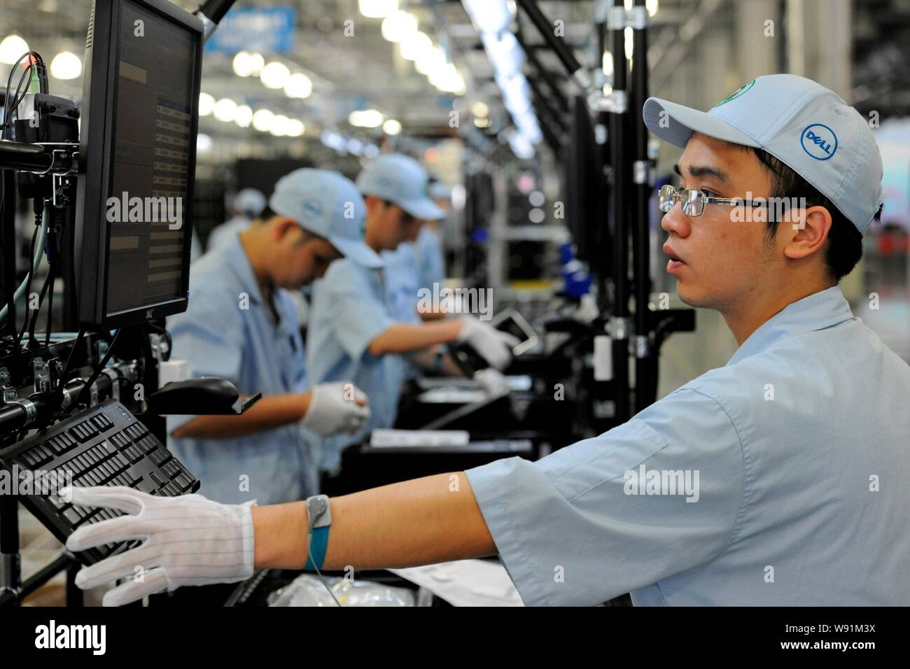 Chinese workers assemble desktop computers on the production line at