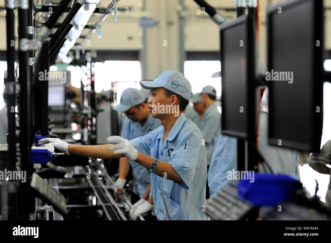 Chinese workers assemble desktop computers on the production line at the global operations site