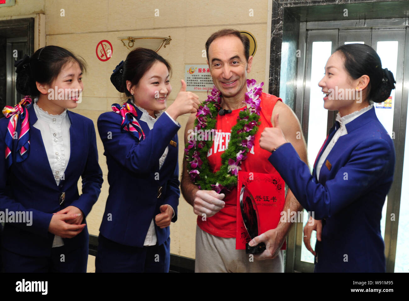 French climber Jean-Michel Casanova, second right, poses with Chinese  hostesses after climbing up the Bailong Elevator, also known as the Hundred  Drag Stock Photo - Alamy