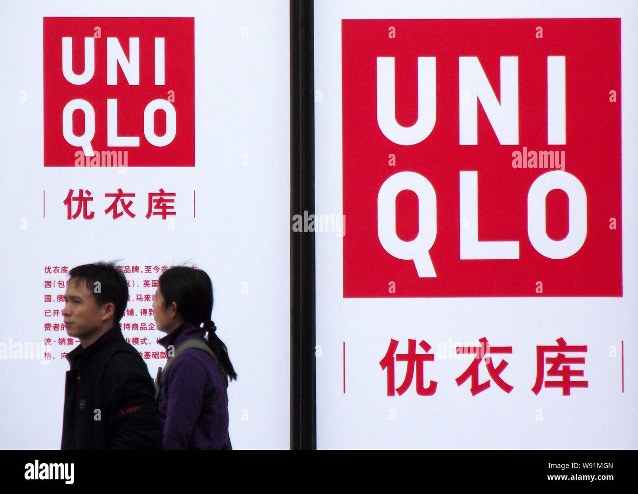 FILE--Pedestrians walk past an advertisement for Uniqlo in Nanjing, east  Chinas Jiangsu province, 31 March 2013. Japans Fast Retailing Co., opera  Stock Photo - Alamy