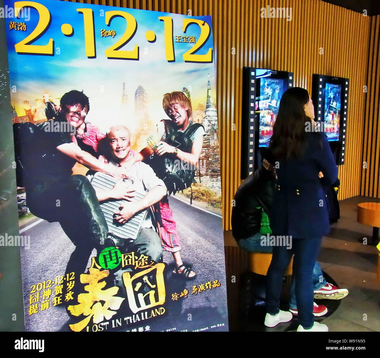 --FILE--Chinese moviegoers wait next to a poster of the movie, Lost in ...