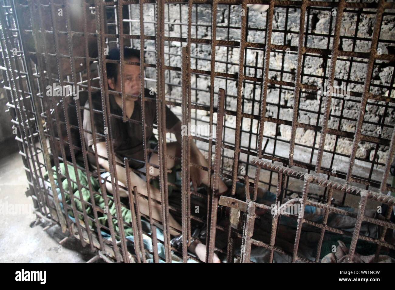 Mentally-ill man Wu Yuanhong, whose feet are chained, sits in a cage at  home in Lijiachong village, Ruichang city, east Chinas Jiangxi province, 24  Ma Stock Photo - Alamy
