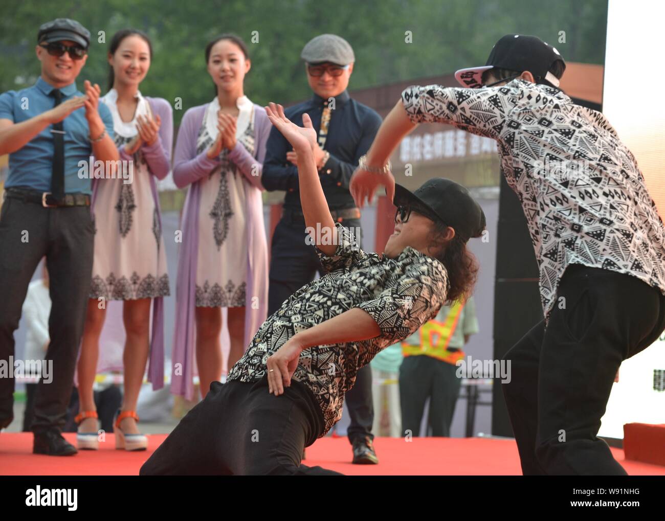 A pair of Chinese twins dances at the launch ceremony of the 10th