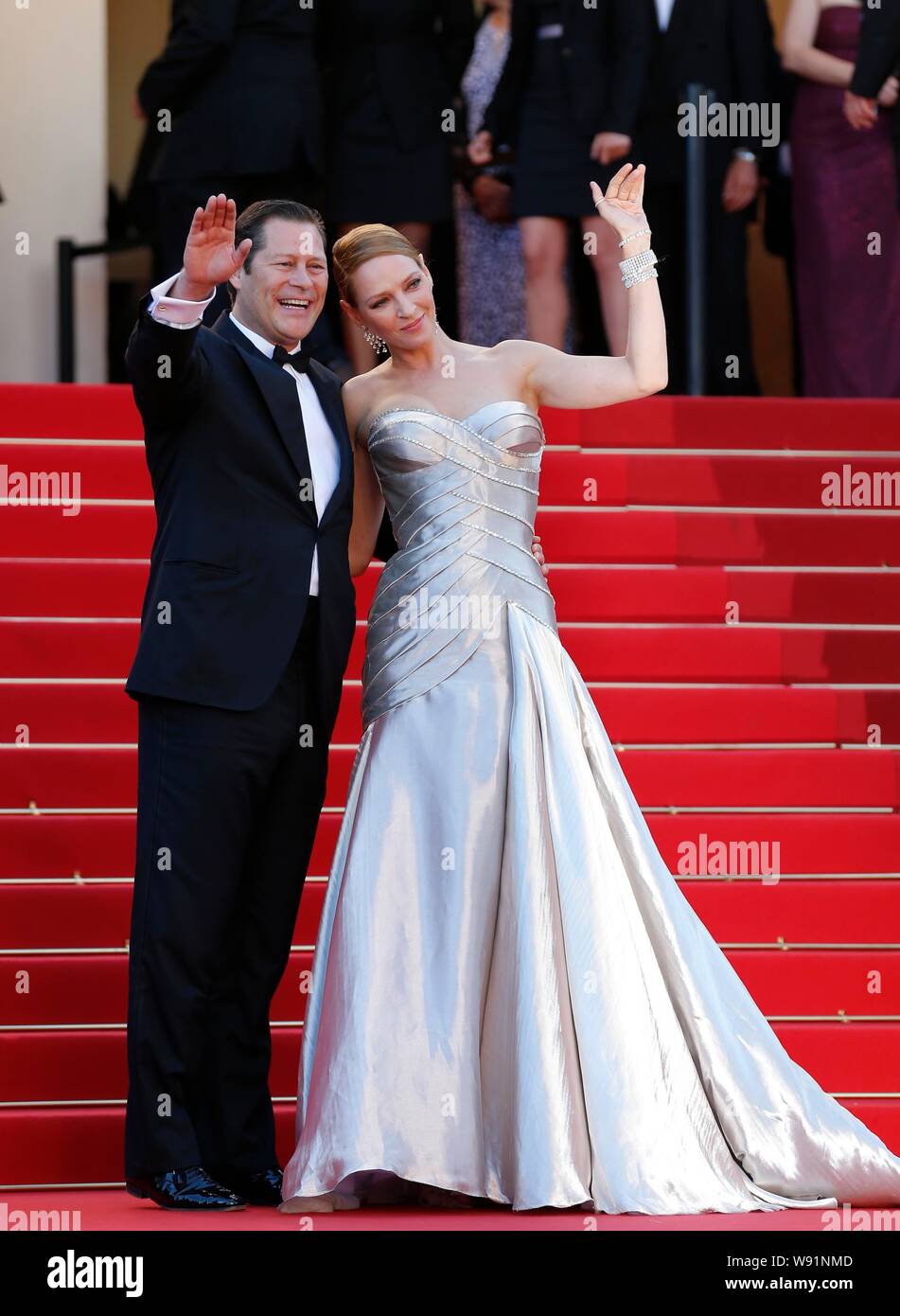 French financier Arpad Busson, left, and U.S. actress Uma Thurman wave on the red carpet as they arrive for the closing ceremony of the 66th Cannes In Stock Photo