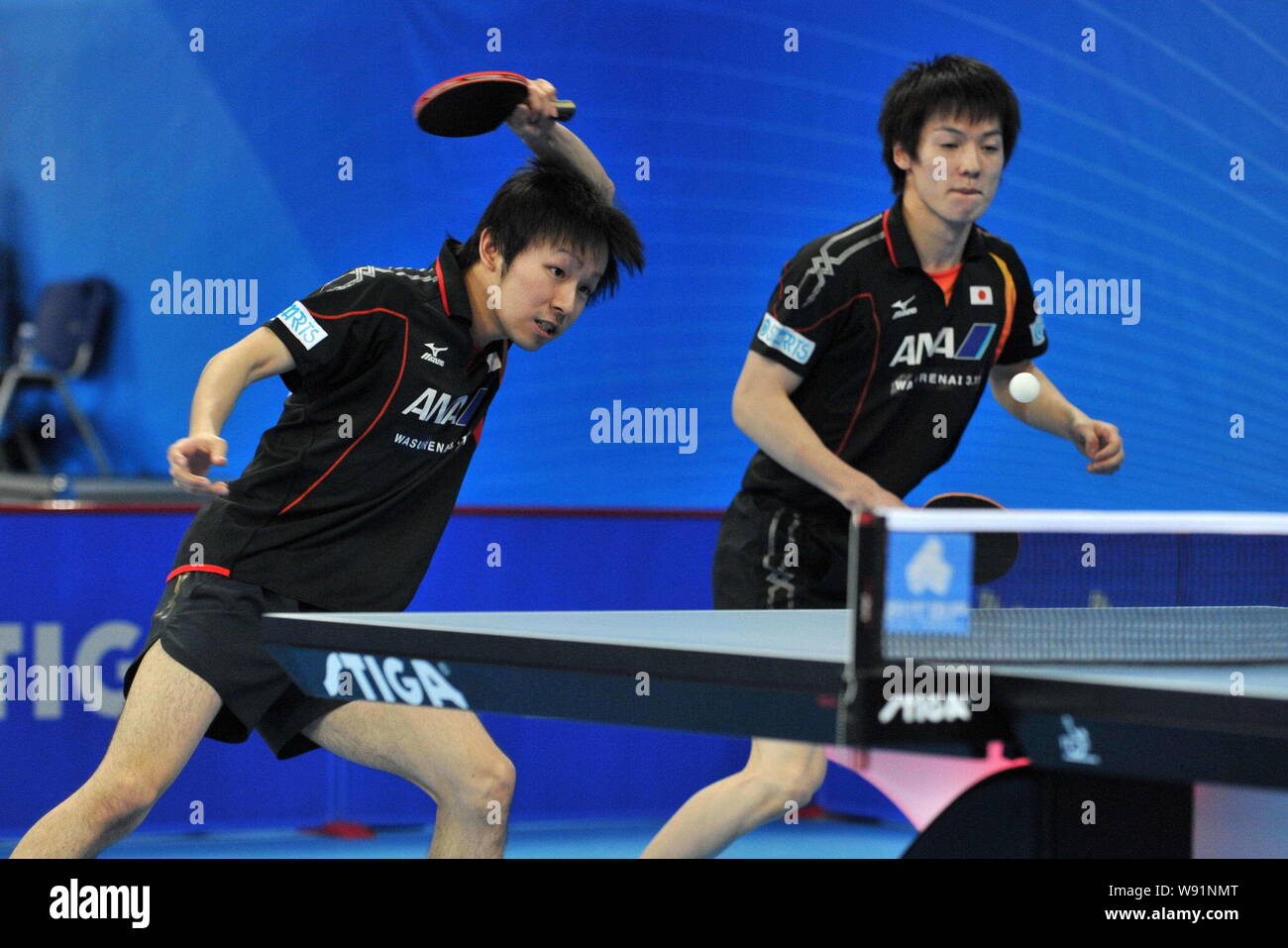 Koki Niwa, left, and Kenta Matsudaira of Japan compete against their Australian counterparts in their mens doubles event during the first round of the Stock Photo