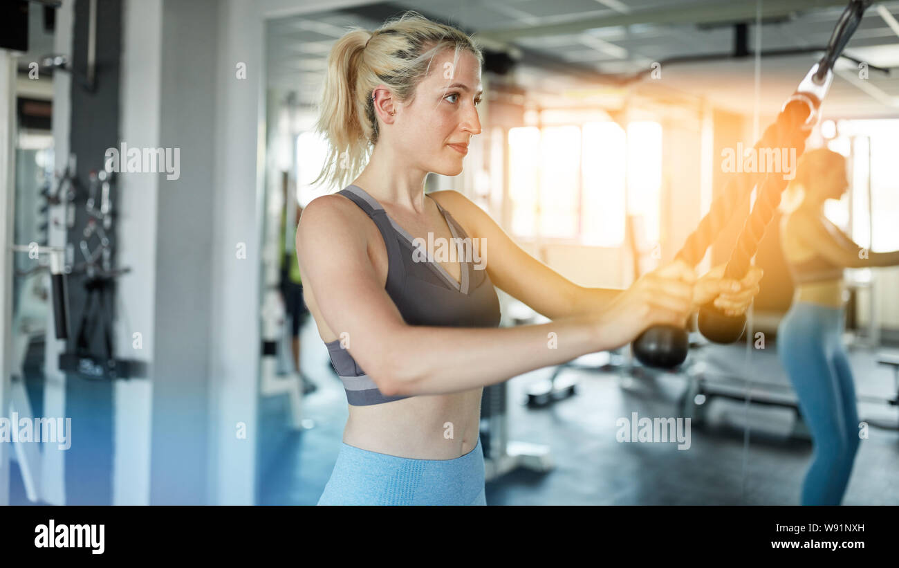 Young woman is doing bodyshaping at train station at workout in the fitness center Stock Photo