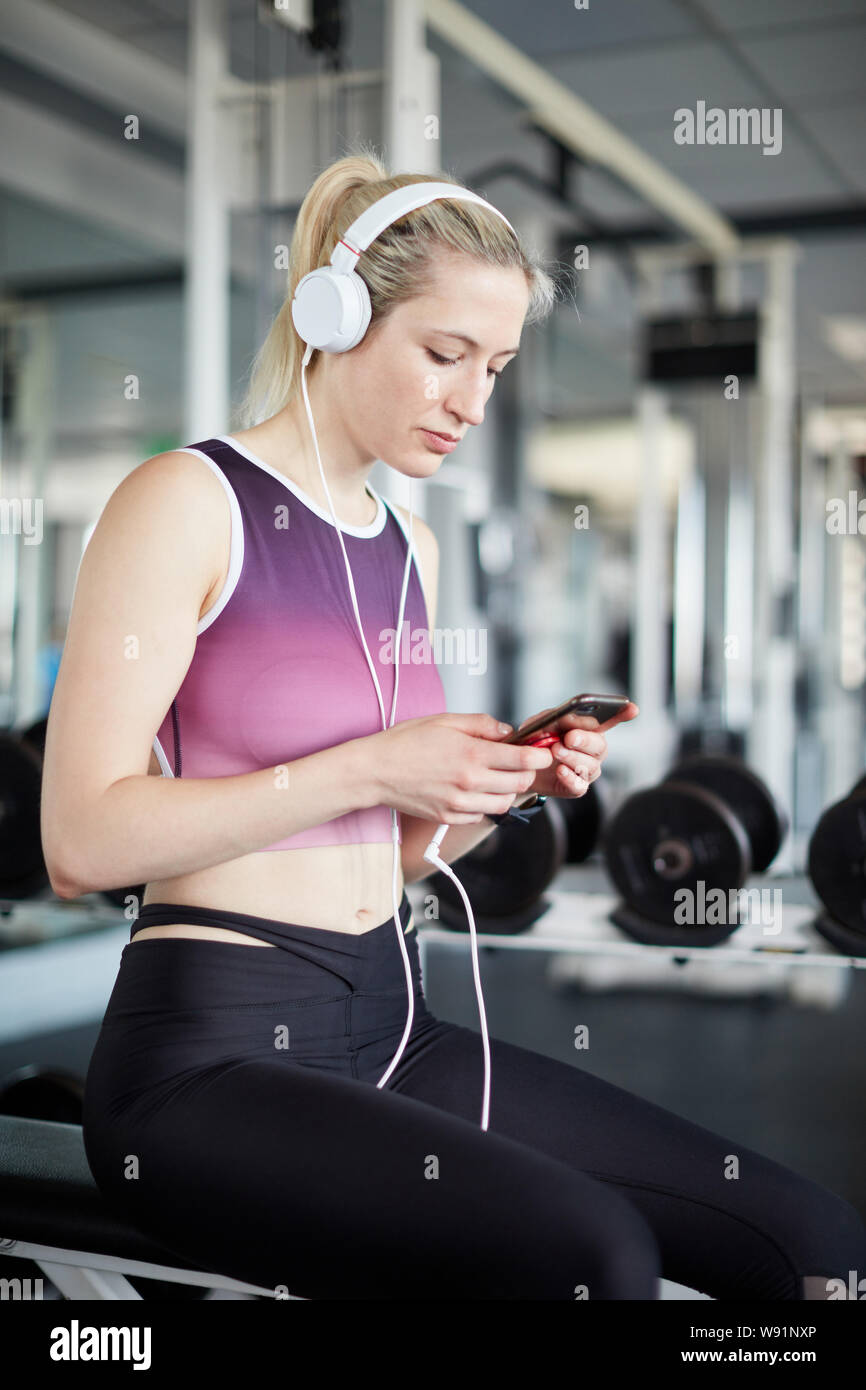 Sporty Young Woman Wearing Pink Sports Clothing is Using Smartphone and  Headphone while Resting after Exercising Stock Photo - Image of music,  icon: 269583478