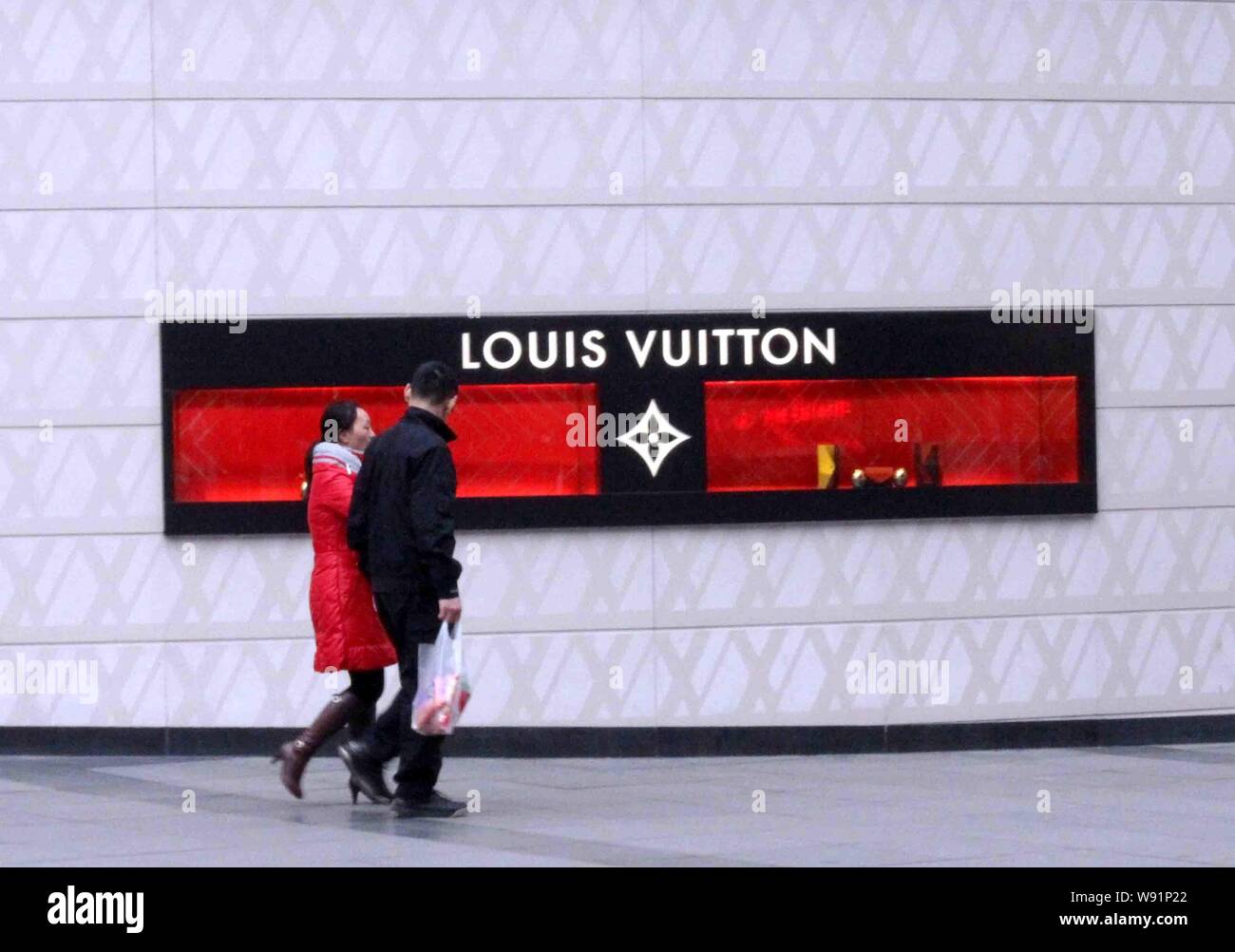 FILE--Pedestrians walk past a fashion store of Louis Vuitton (LV) in  Shanghai, China, 28 October 2013. Luxury-goods leader LVMH Moet Hennessy  Loui Stock Photo - Alamy
