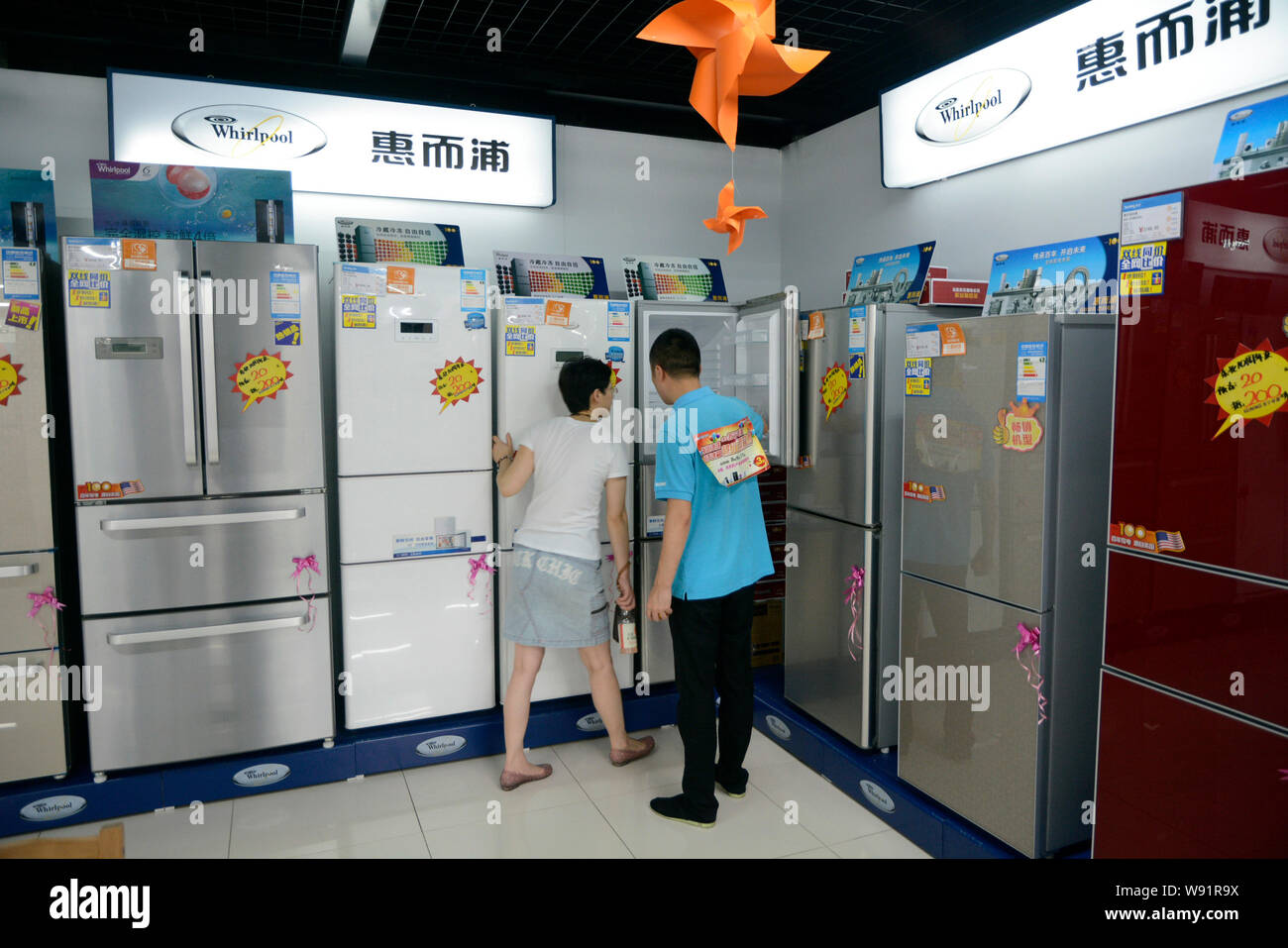 --FILE--A Chinese clerk helps a customer shop for a Whirlpool refrigerator at a home appliances store in Dalian city, northeast Chinas Liaoning provin Stock Photo