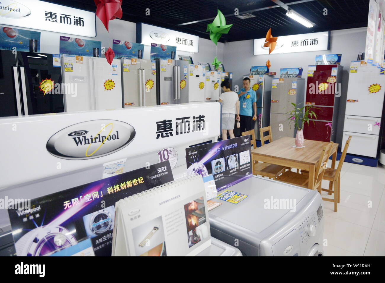 --FILE--A customer shops for a Whirlpool refrigerator at a home appliances store in Dalian city, northeast Chinas Liaoning province, 4 August 2013. Stock Photo