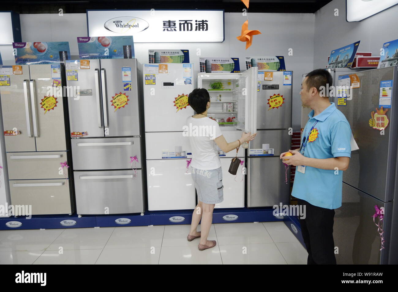 --FILE--A customer shops for a Whirlpool refrigerator at a home appliances store in Dalian city, northeast Chinas Liaoning province, 4 August 2013. Stock Photo