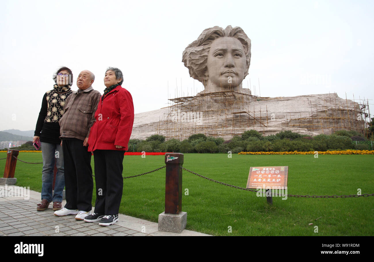 --FILE--Visitors pose for photos in front of the giant stone statue ...