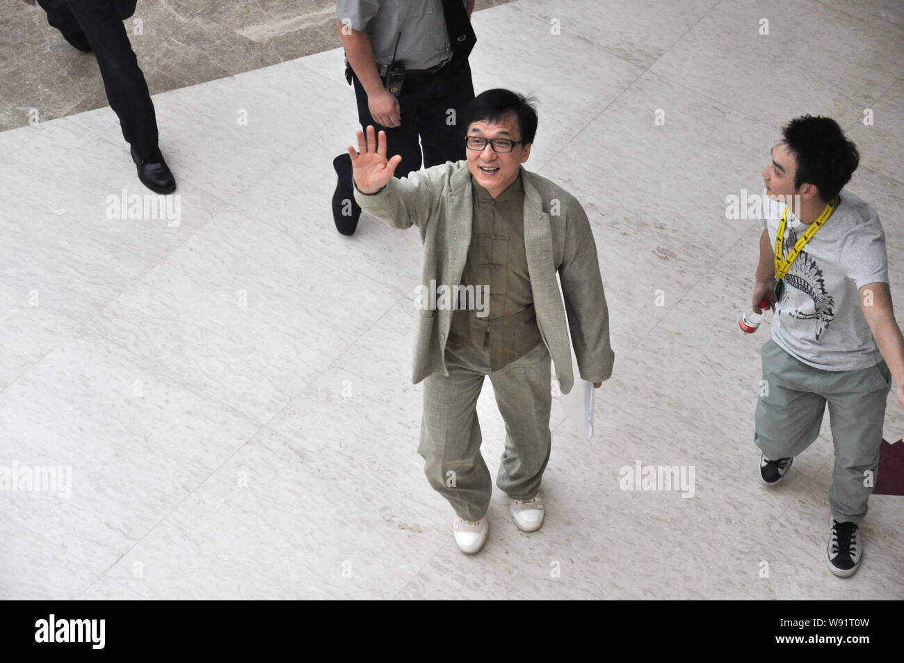 Hong Kong kungfu superstar Jackie Chan, center, waves as he arrives for the inauguration of a philanthropy research center at the Communication Univer Stock Photo