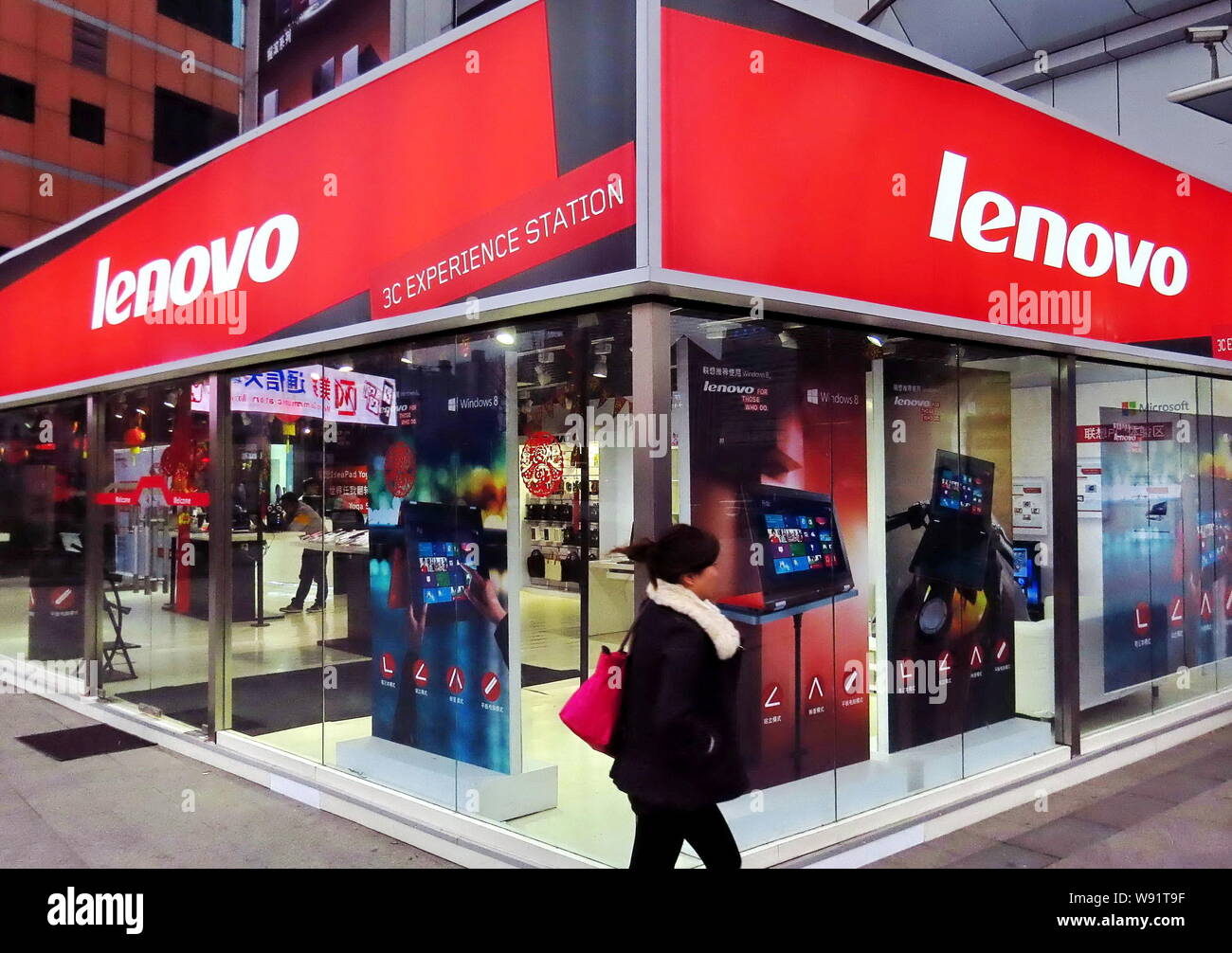 --FILE--A pedestrian walks past a Lenovo store in Shanghai China, 21 February 2013.   To offset falling PC sales and reduce its reliance on ThinkPad n Stock Photo