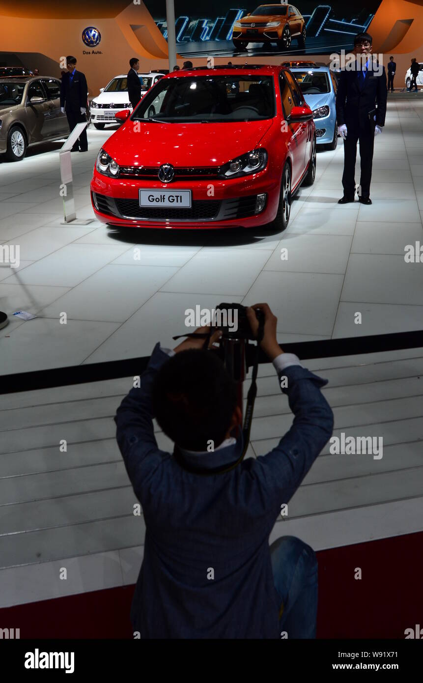 --FILE--A visitor takes photos of a Golf GRT car at the stand of Volkswagen at the 15th Shanghai International Automobile Industry Exhibition, known a Stock Photo