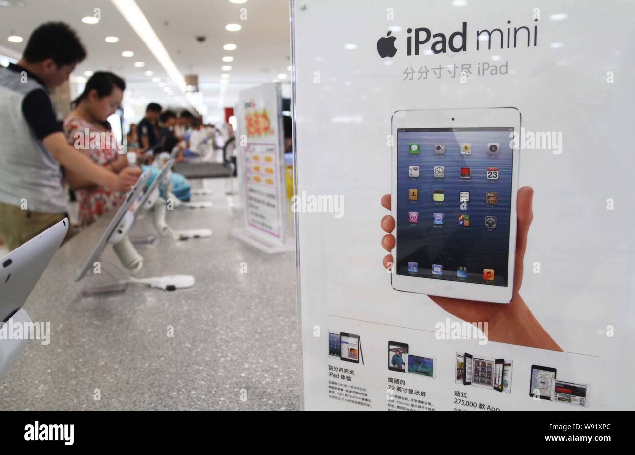 --FILE--Customers try out iPad mini tablet PCs of Apple at a store in Xuchang city, central Chinas Henan province, 16 June 2013.   Apple has lost more Stock Photo