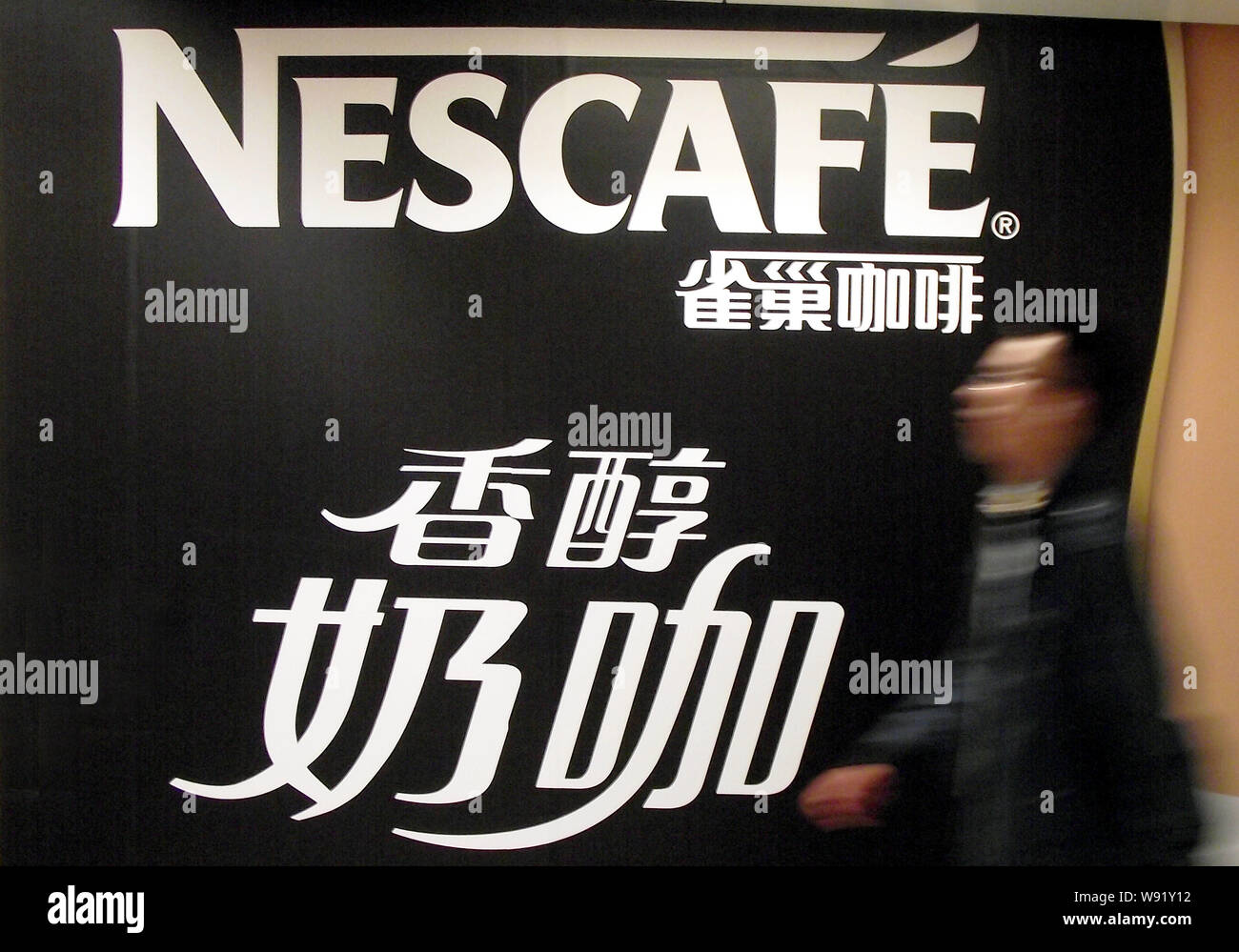 --FILE--A pedestrian walks past an advertisement for Nescafe of Nestle in Nanjing, east Chinas Jiangsu province, 1 July 2013.   Nestle SA, the worlds Stock Photo