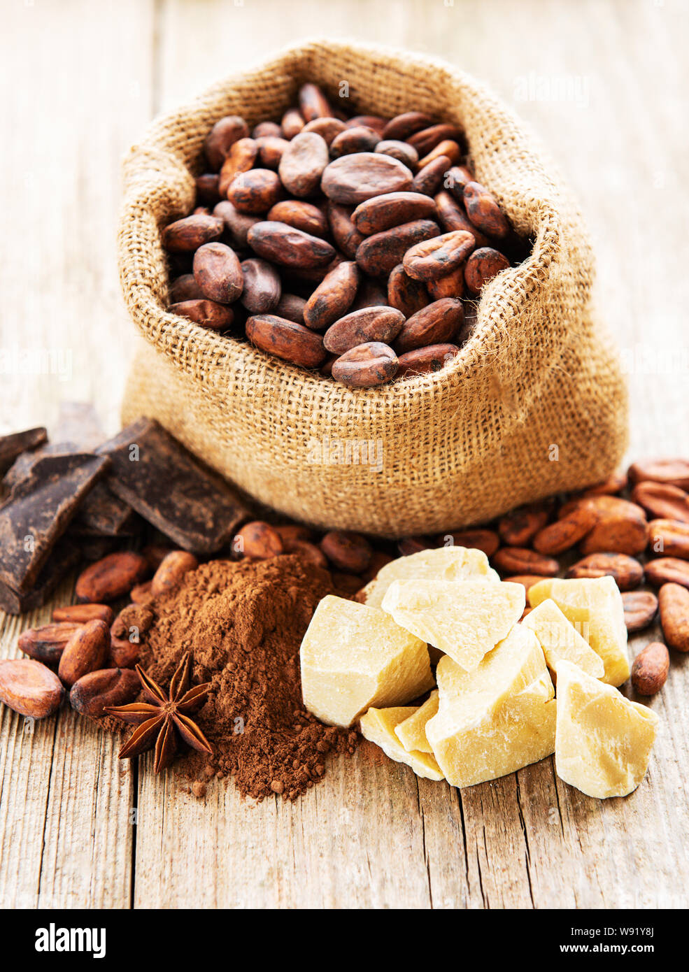 Natural cocoa beans, powder, chocolate and butter on a old wooden ...