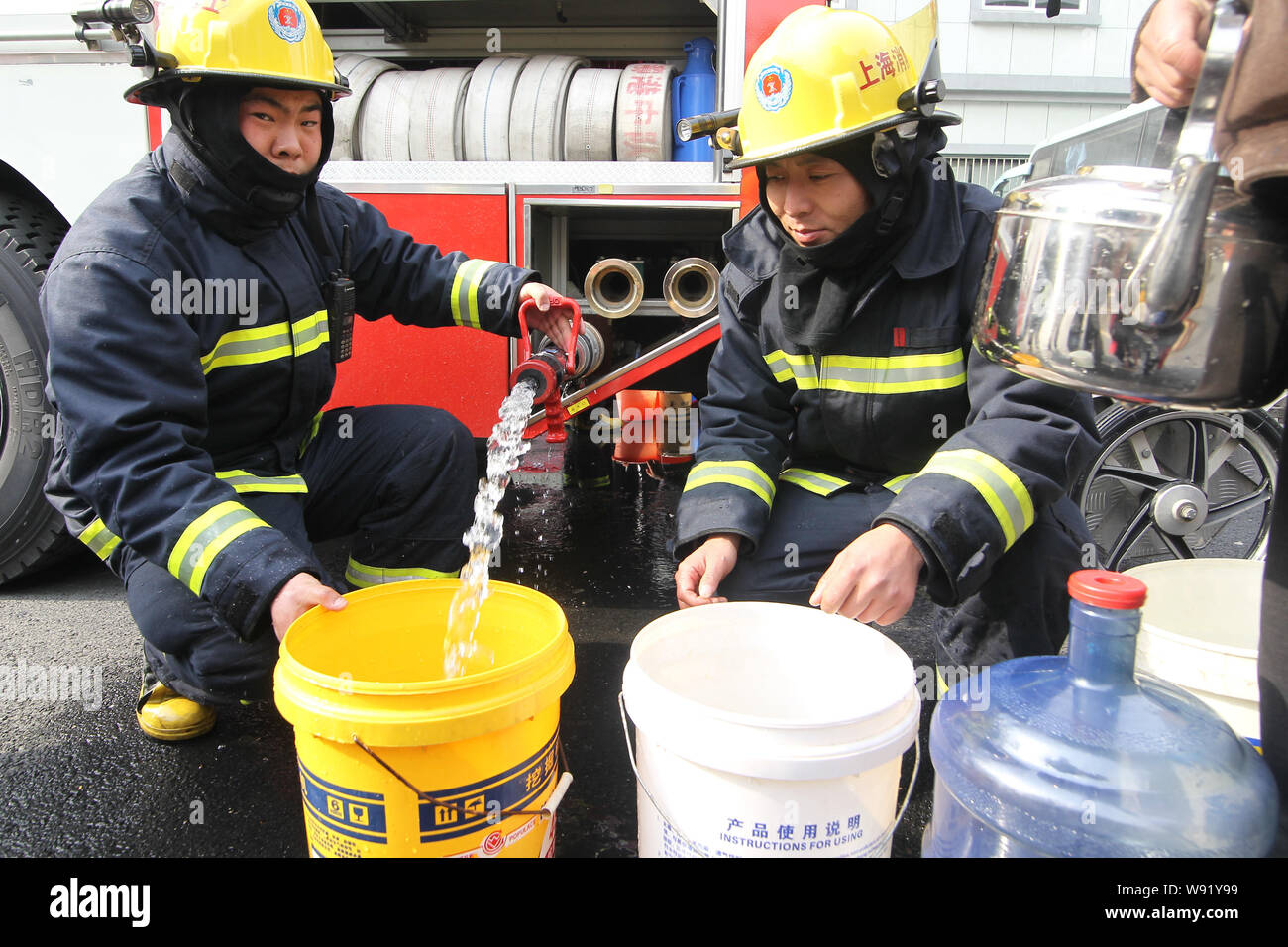 Chinese firefighters supply local residents with water from a fire ...