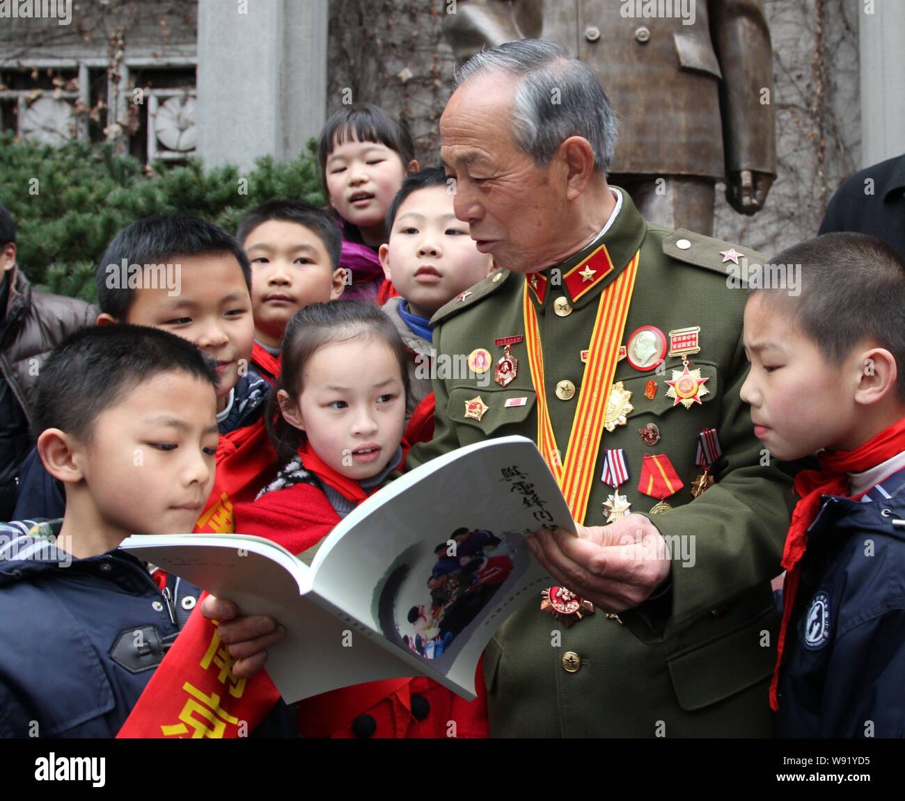 --FILE--Zhao Mingcai, a contemporary comrade of Lei Feng, the nations most famous Good Samaritan, talks to elementary school students in Nanjing, east Stock Photo