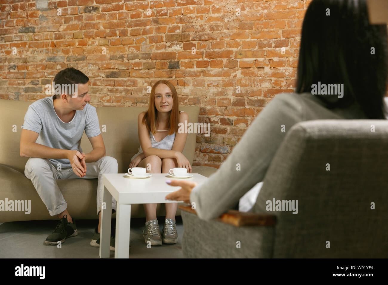 Couple in therapy or marriage counseling. Psychologist, counselor, therapist or relationship consultant giving advice. Man and woman sitting on a psychotherapy session. Family, mental health concept. Stock Photo