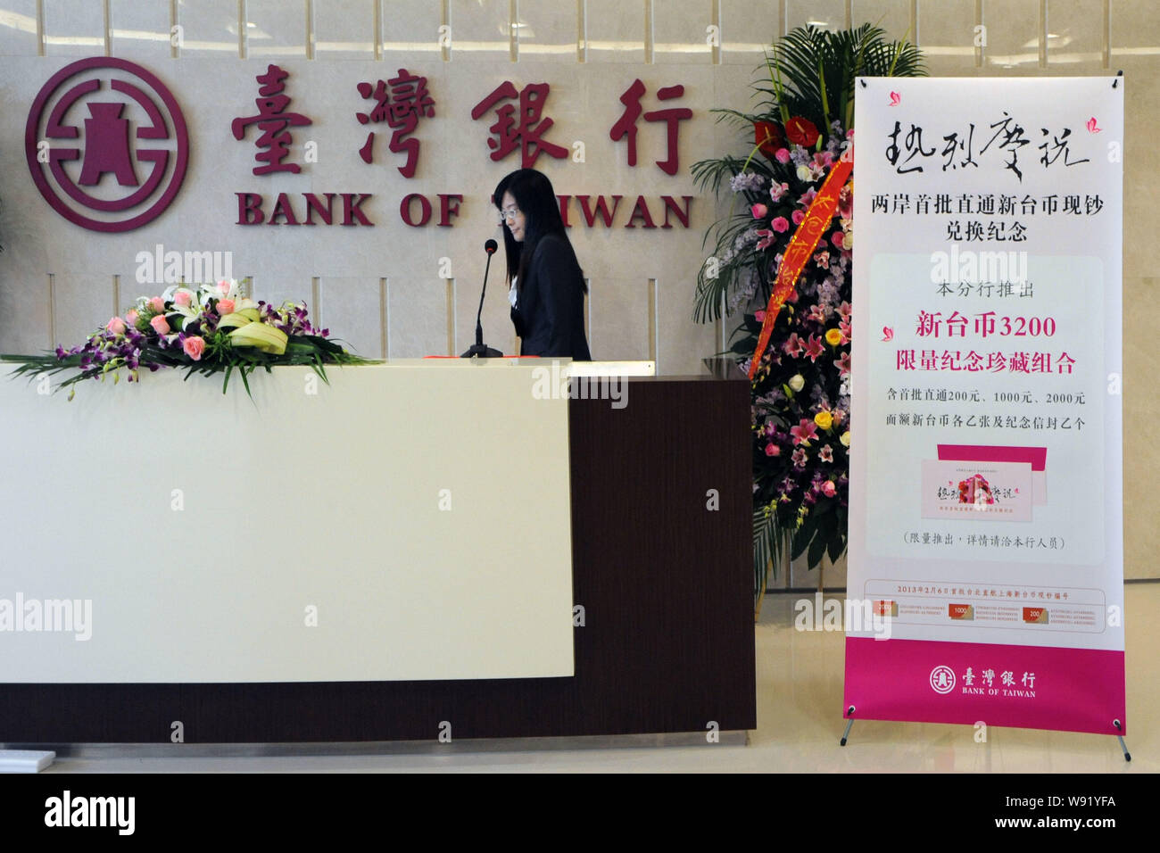 A clerk attends the launch ceremony for the exchange service between the  yuan and the New Taiwan dollar at the Shanghai branch of Bank of Taiwan in  Sh Stock Photo - Alamy