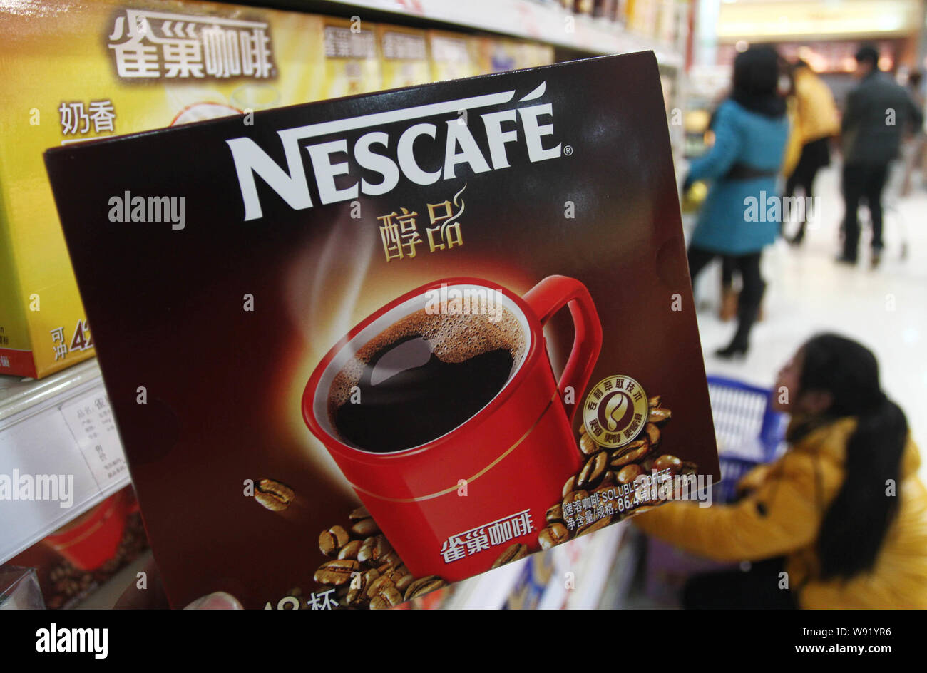 --FILE--Customers buy Nescafe coffee of Nestle at a supermarket in Xuchang city, central Chinas Henan province, 16 February 2013.   Nestle announced p Stock Photo