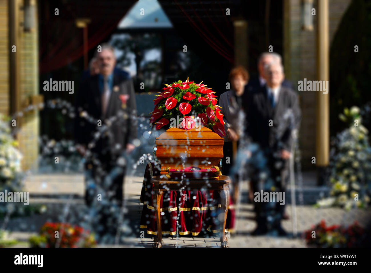 Blurred image of family standing by a coffin at a funeral Stock Photo