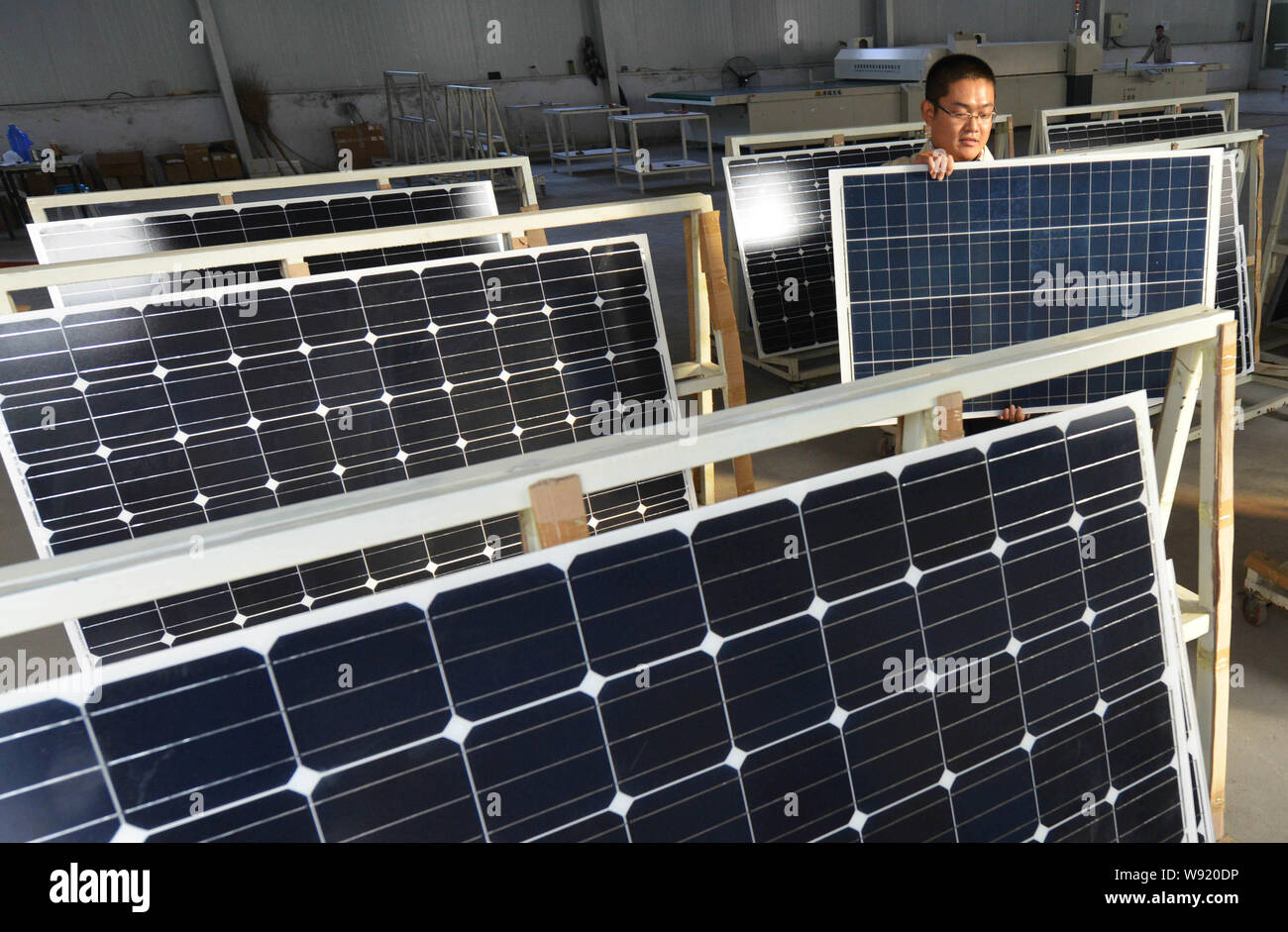 --FILE--A Chinese worker carries solar panels at the factory of Shandong Hilight Solar Co., Ltd. in Zouping county, Binzhou city, east Chinas Shandong Stock Photo