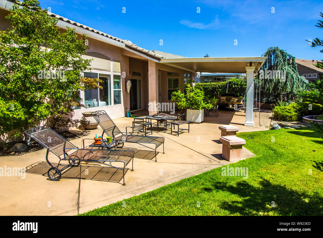 Relaxing Rear Yard Patio Setting With Wrought Iron Furniture Stock