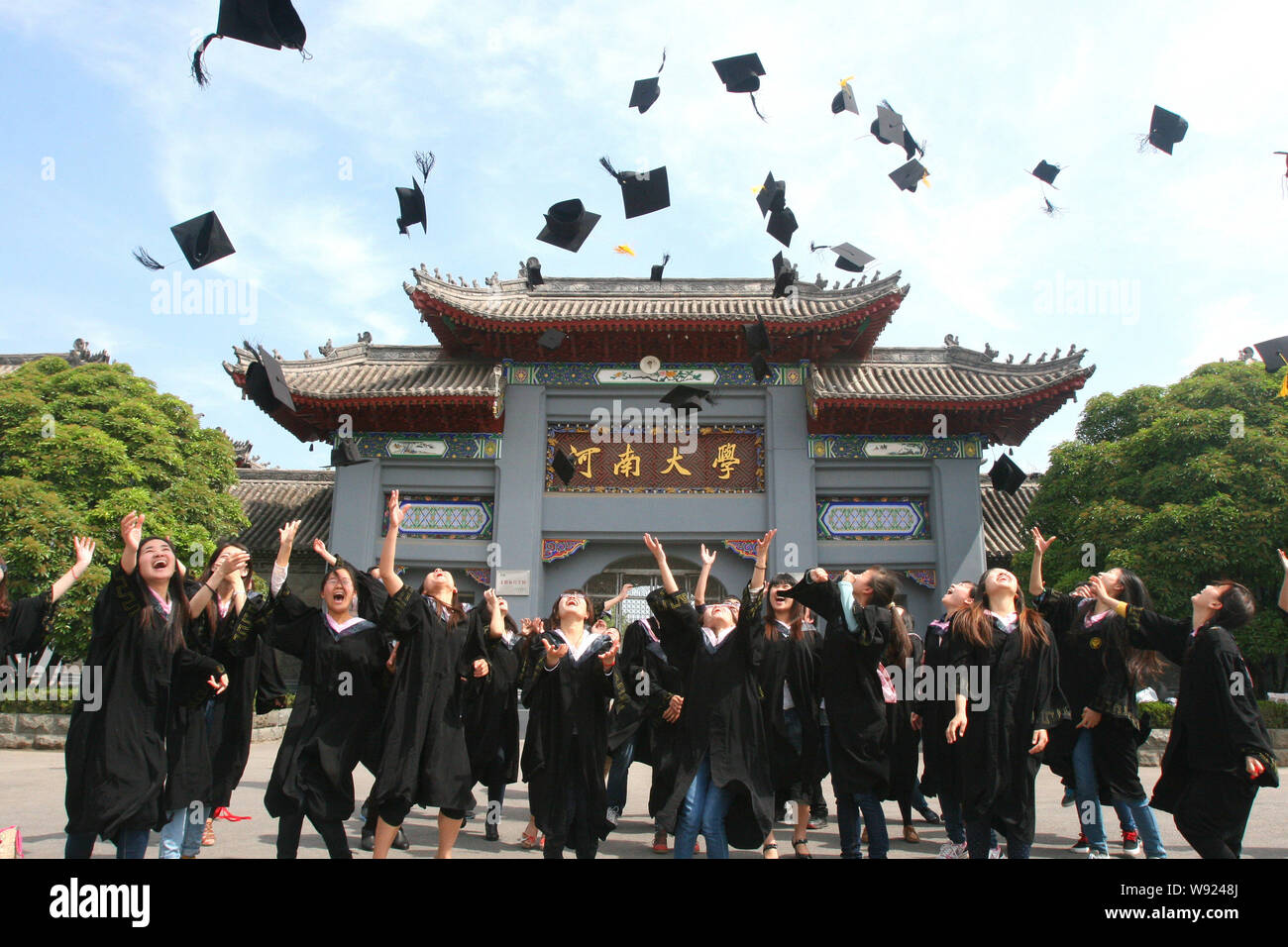 FILE--Graduates in gowns through their caps for celebrating at Henan University in Kaifeng city, east Chinas Henan province, 10 May 2013.   Public exp Stock Photo