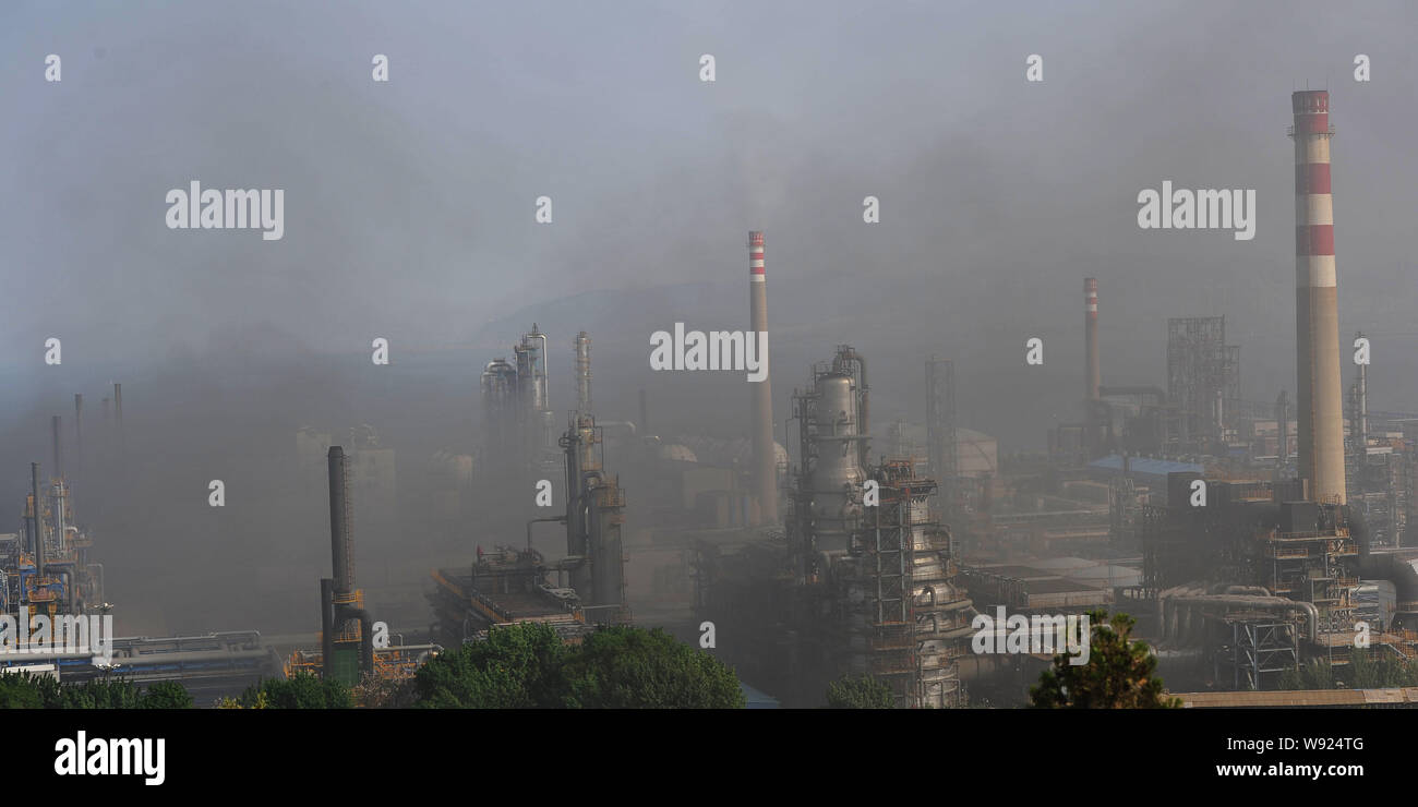 Black smoke rises as oil tanks are on fire after an explosion at a refinery of PetroChina in Dalian city, northeast Chinas Liaoning province, 2 June 2 Stock Photo