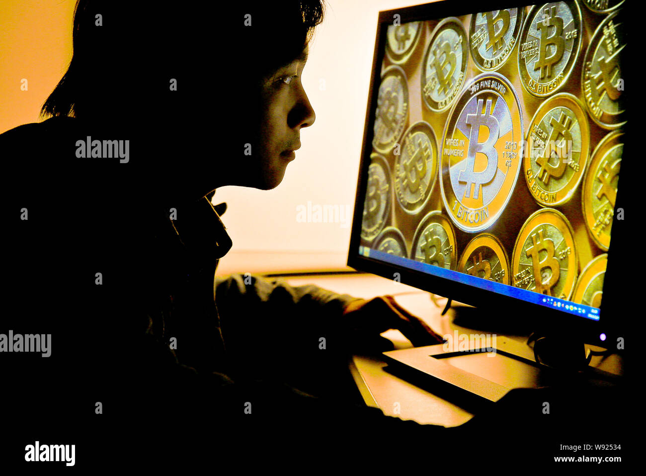 A Chinese netizen browses a photo of Bitcoins on his desktop computer in Guangzhou city, south Chinas Guangdong province, 9 December 2013.   Some vend Stock Photo