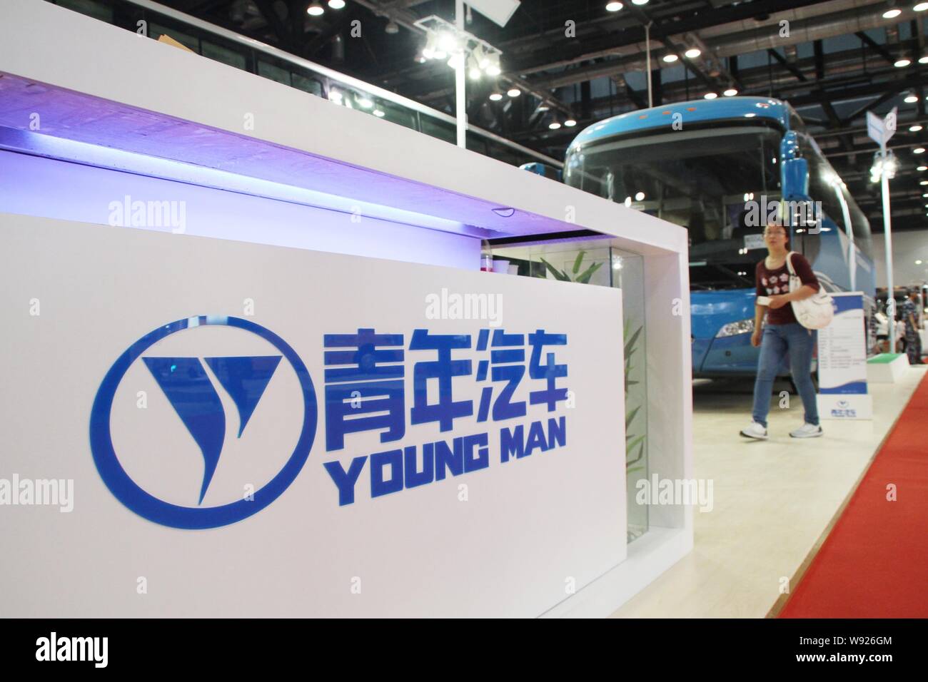 --FILE--A visitor walks past a bus on display at the stand of China Youngman Automobile Group Co., Ltd. during an exhibition in Beijing, China, 22 May Stock Photo