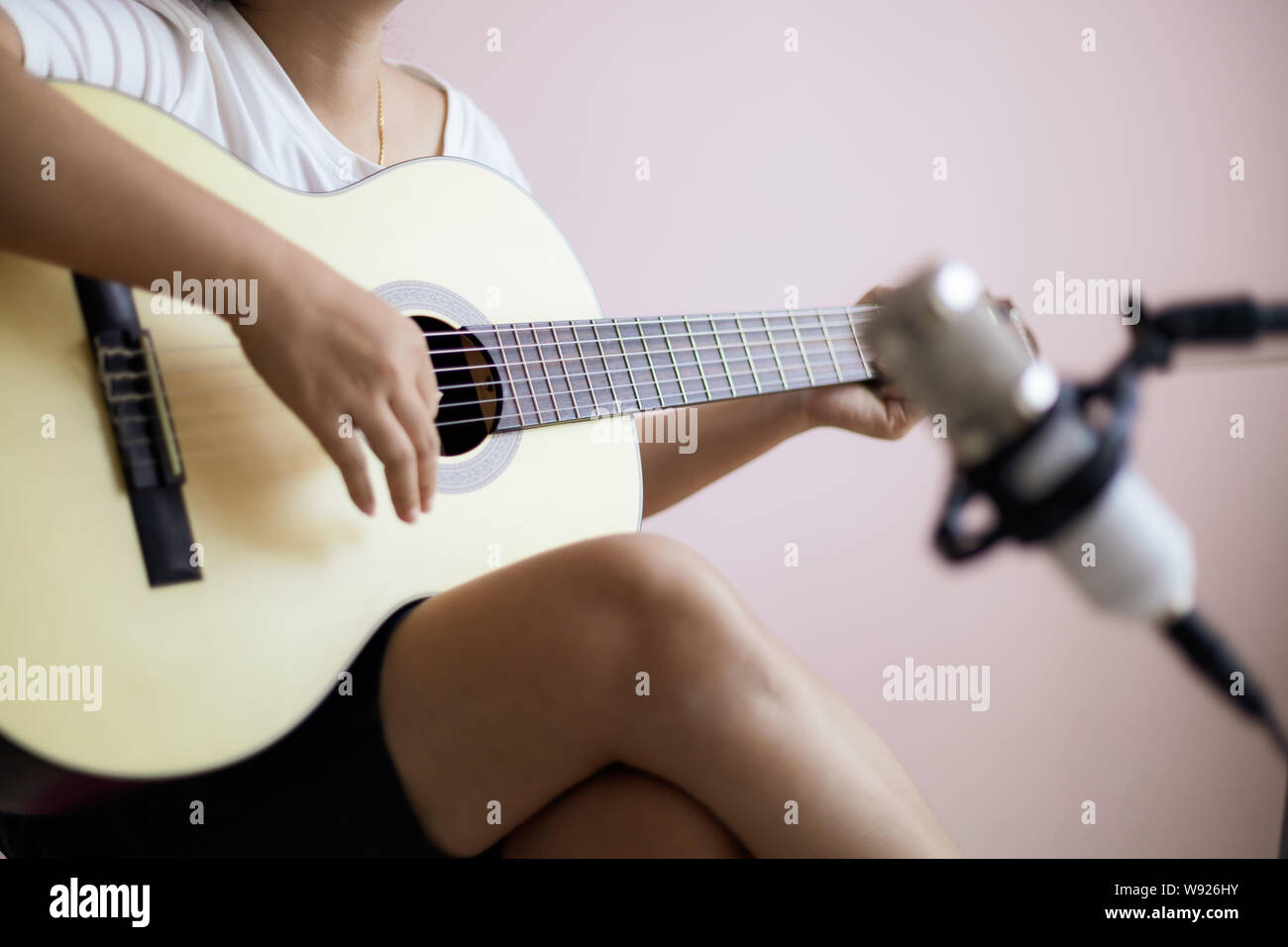 Asian woman play acoustic classic guitar for jazz and easy listening song and record with microphone select focus shallow depth of field Stock Photo