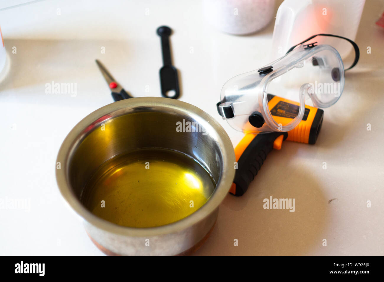 Shot of steel vessel, thermometer, goggles, spatula used for making home made hand made soap with blurred background. These are essential items for sa Stock Photo