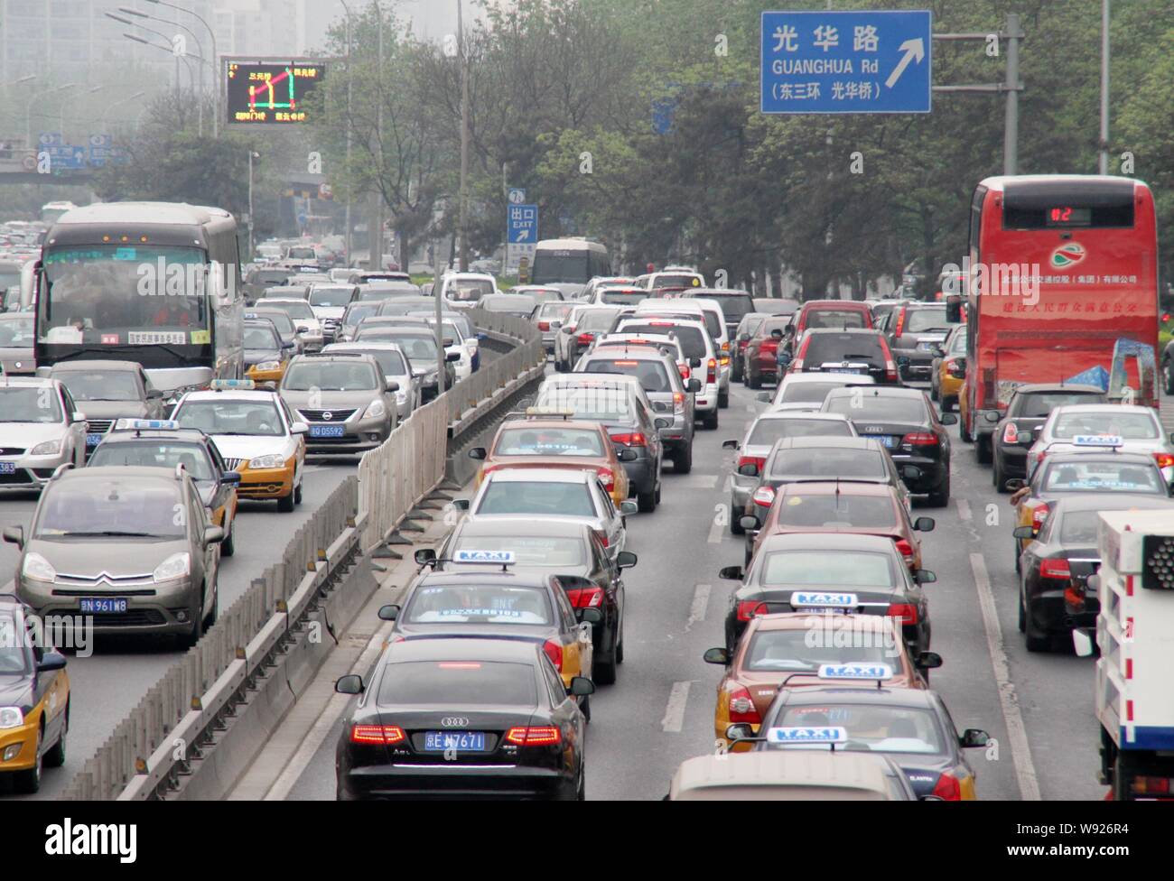 --FILE--Masses of cars and buses move slowy in a traffic jam on a road in Beijing, China, 28 April 2013.   Following the footsteps of bigger metropoli Stock Photo