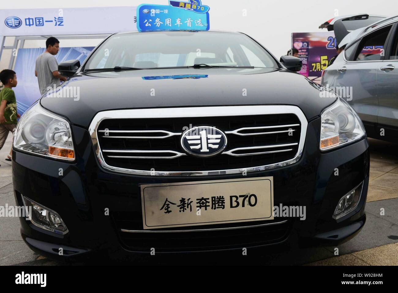 --FILE--Chinese visitors look at a Besturn B70 car during an automobile expo in Qingdao, east Chinas Shandong province, 6 July 2013.   Chinese automak Stock Photo