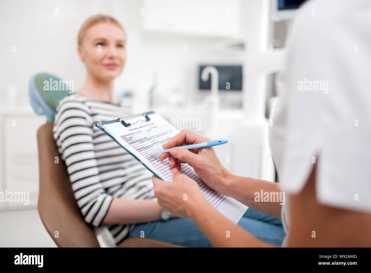 Dentist writing prescriptions for her new patient Stock Photo Alamy