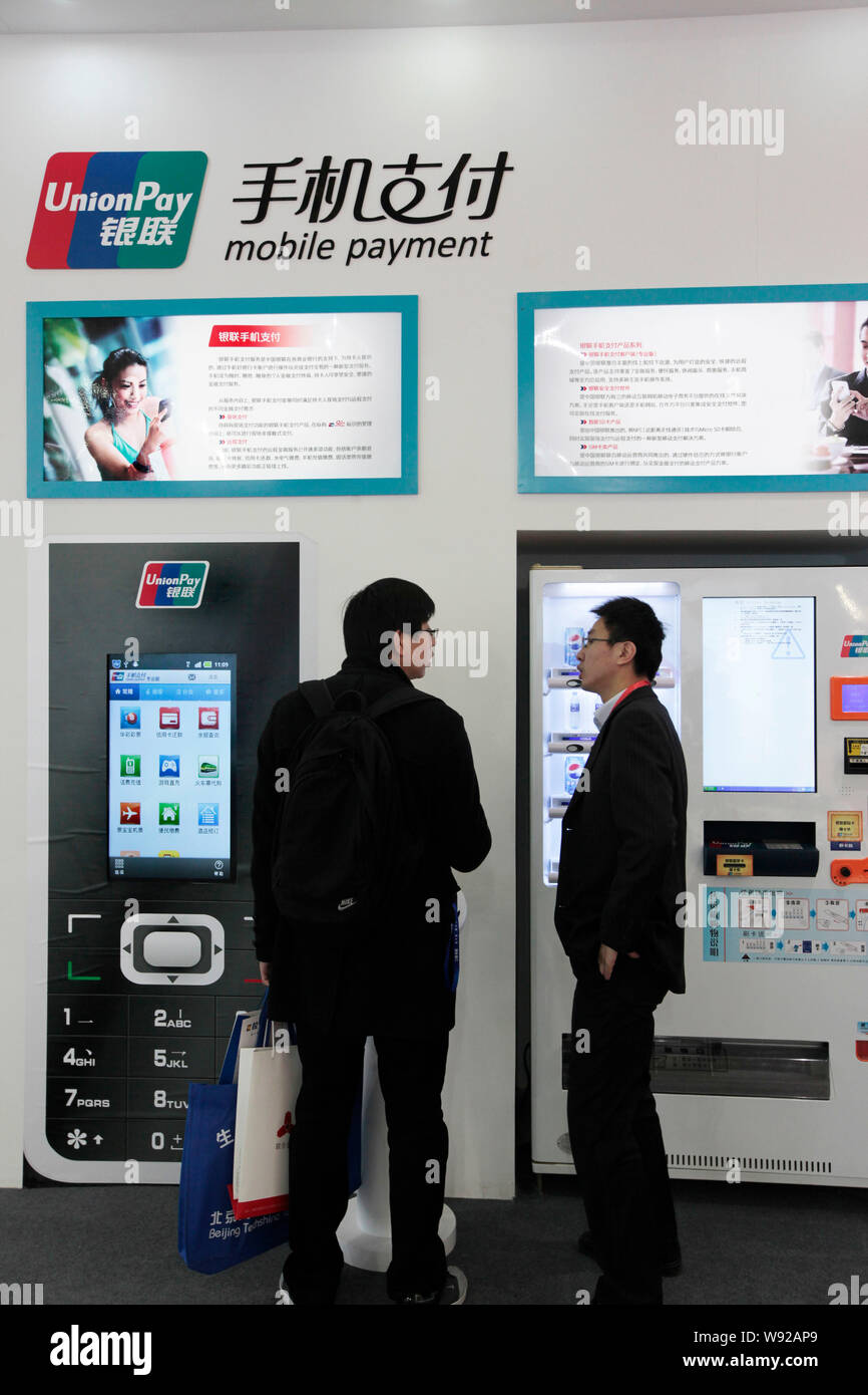--FILE--People visit the stand of UnionPay mobile payment during an exhibition in Beijing, China, 22 December 2012.   Online payment transactions hand Stock Photo