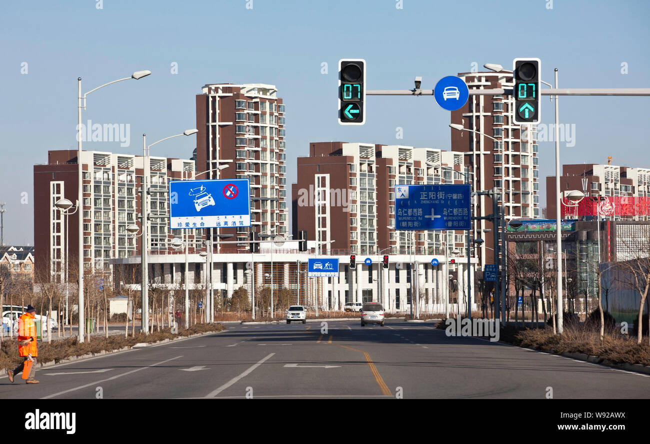 Cars travel on a nearly empty road in Kangbashi district, Ordos city ...
