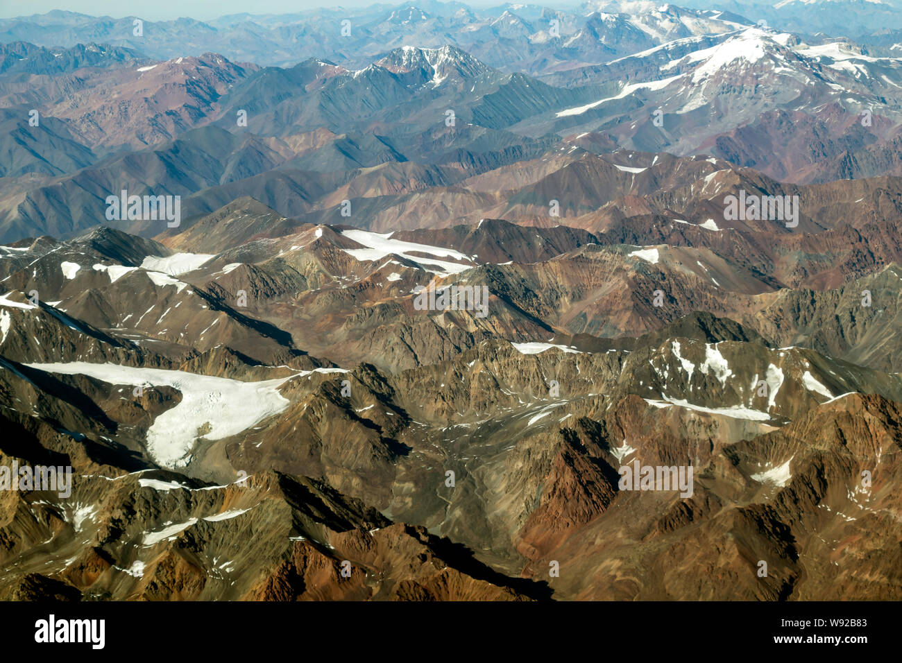 Andean mountain range with mountains peaks covered under snow, aerial