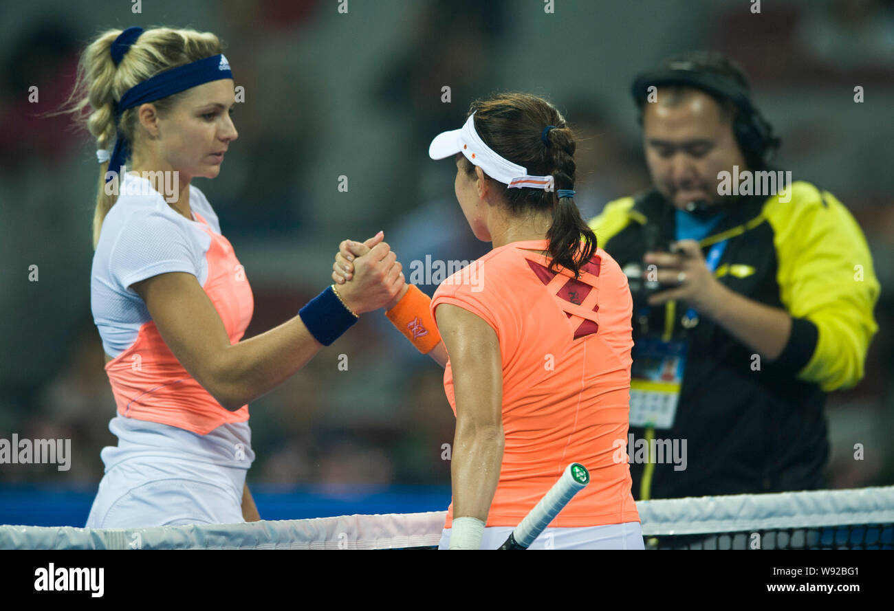 Maria Kirilenko of Russia, left, holds hands with Zheng Jie of China after their first-round match of the 2013 China Open tennis tournament in Beijing Stock Photo