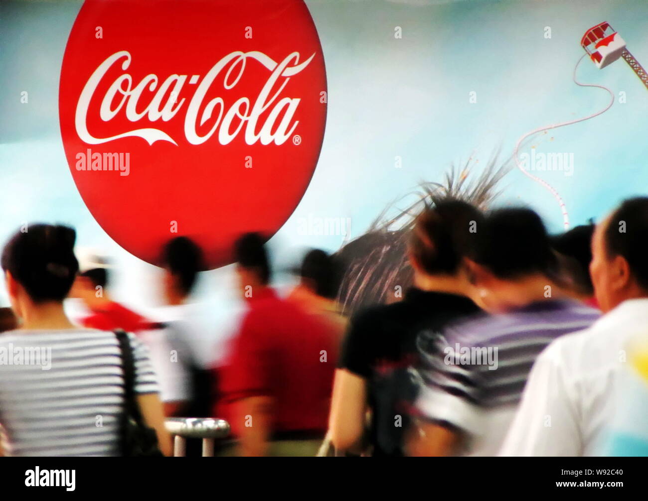 --FILE--Pedestrian walks past an advertisement of Coca-Cola in Shanghai ...