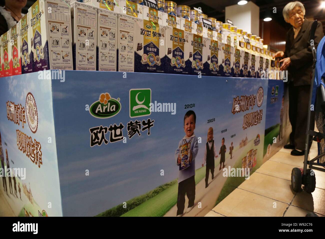 --FILE--A customer buys boxes of Mengniu Arla milk powder at a supermarket in Xuchang, central Chinas Henan province, 5 October 2013.   China Mengniu Stock Photo