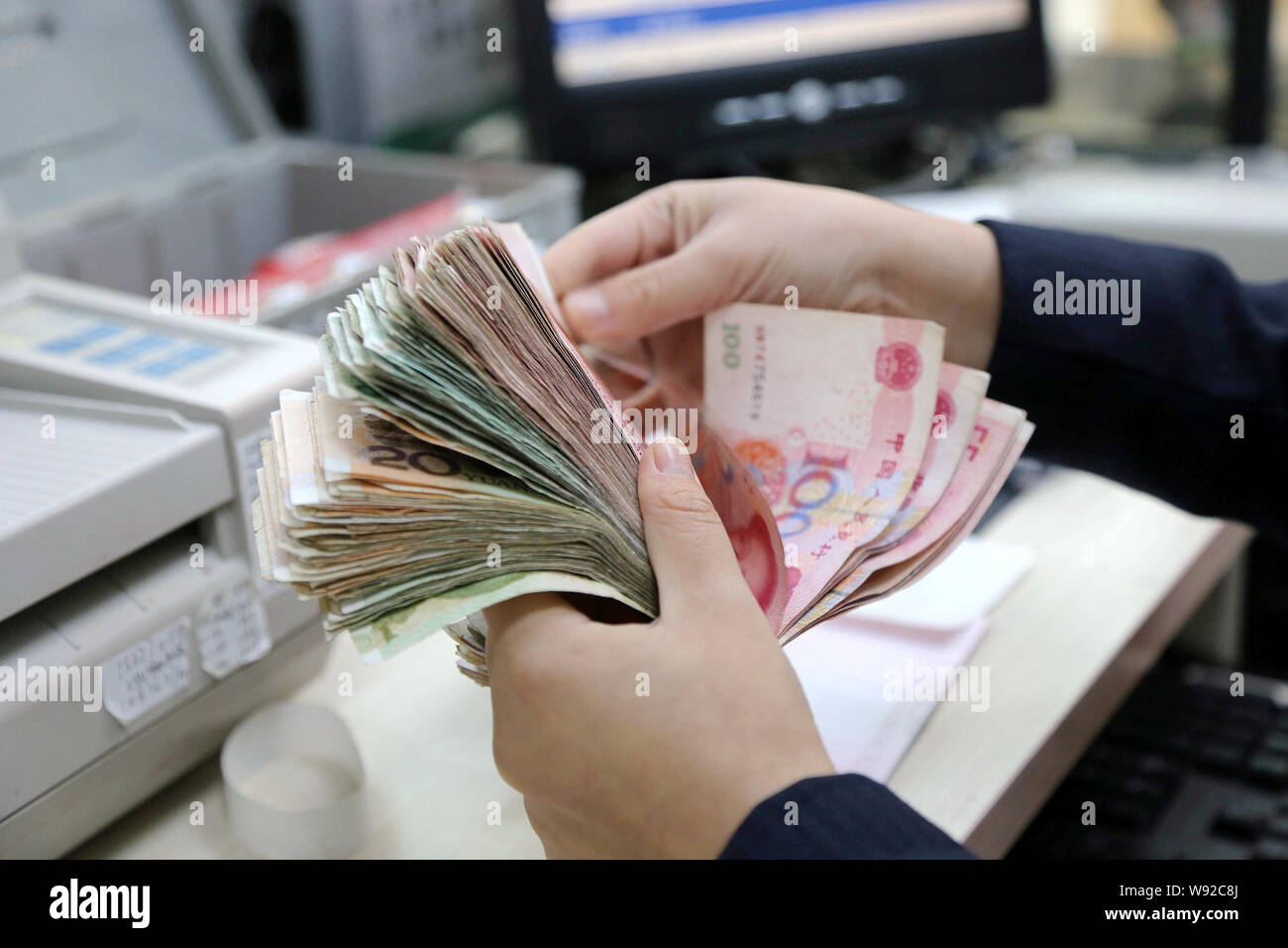Counting Rmb --FILE--A Chinese clerk counts RMB (renminbi) yuan banknotes at a bank ...