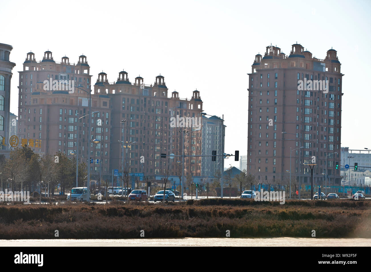 Cars pass by new residential apartment buildings in Kangbashi district ...