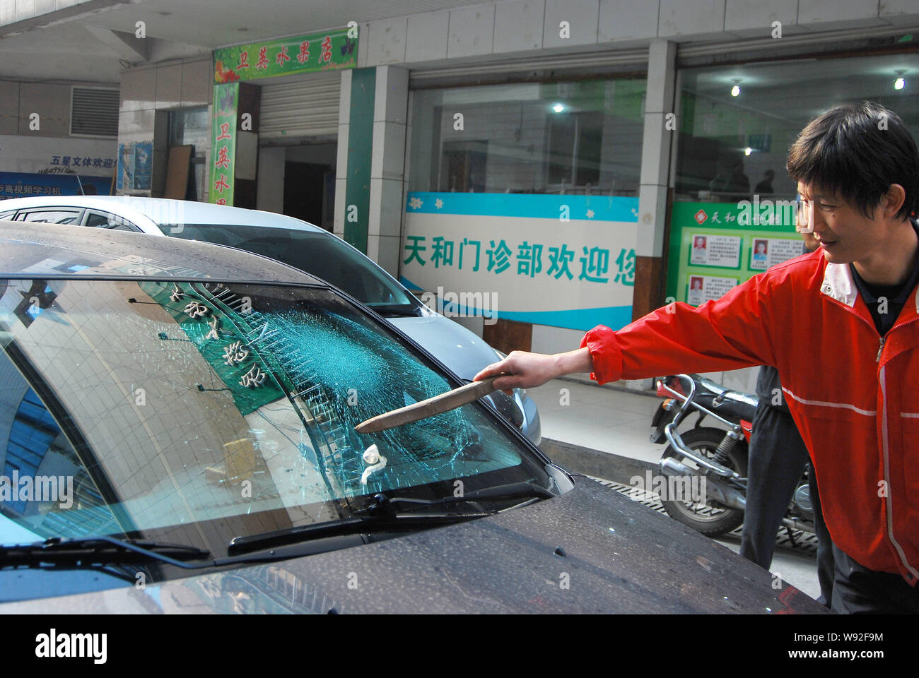 The car owner clears away the used condom from the shattered front windshield of his Chevrolet Cruze in Jiande city, east Chinas Zhejiang province, 5 Stock Photo