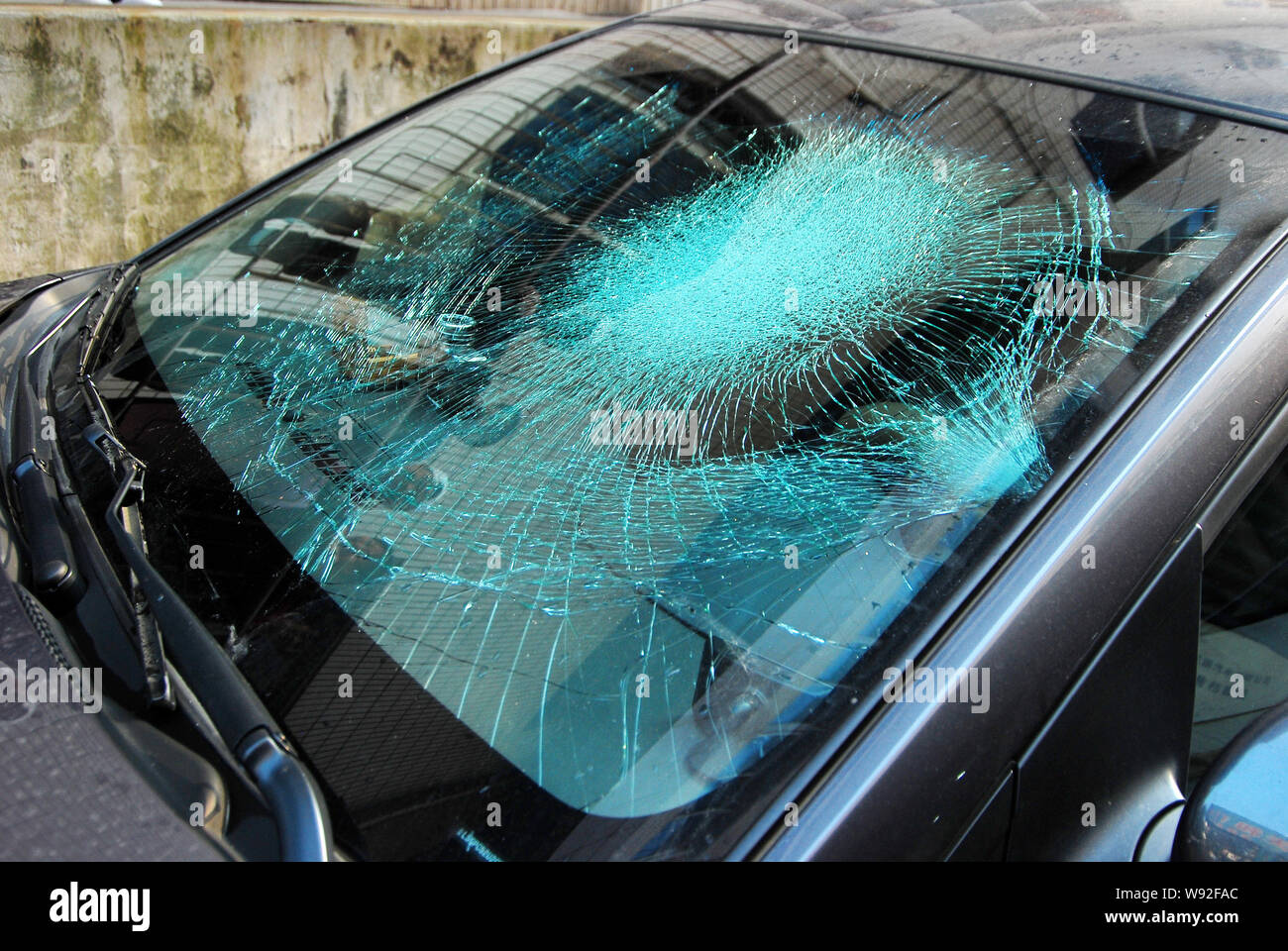 View of the shattered front windshield of a Chevrolet Cruze after it was hit by a used condom falling from an unknown floor of a high-rise residential Stock Photo