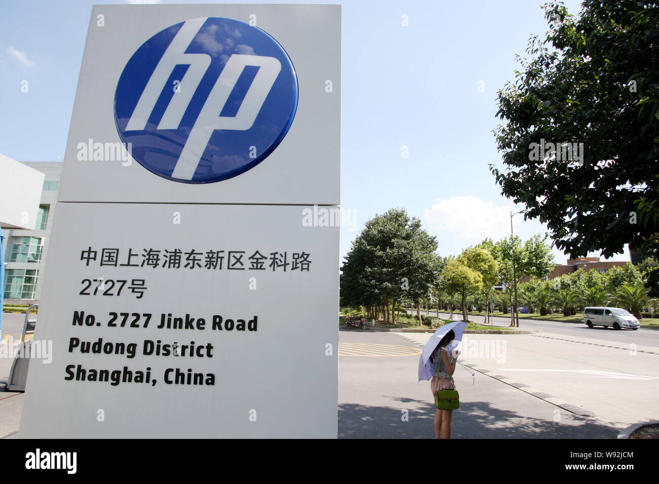 FILE--A pedestrian stands next to a signage of HP at Zhangjiang Hi-Tech  Park in Pudong, Shanghai, China, 18 July 2013. Hewlett-Packard Development  Stock Photo - Alamy